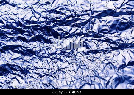Blue texture of crumpled sheet of aluminum foil. Foil background. Stock Photo