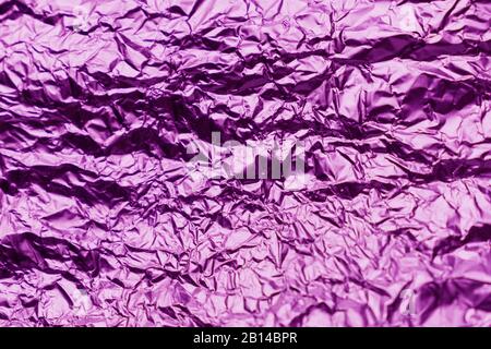 Purple crumpled sheet of aluminum foil. Foil background. Stock Photo