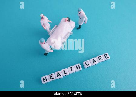 Miniature medical toy people - Health care sentences with blue or teal background Stock Photo
