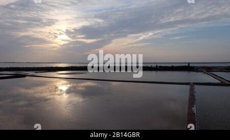 Water flooded field with the reflection of evening sky with setting sun. Stock Photo