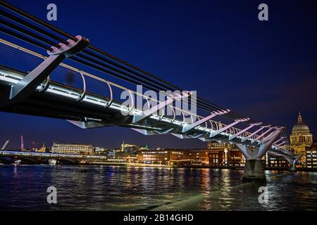 Night view of the Millennium Bridge and St Paul's Cathedral in London, UK. View over the River Thames to two of London's famous landmarks 2020.