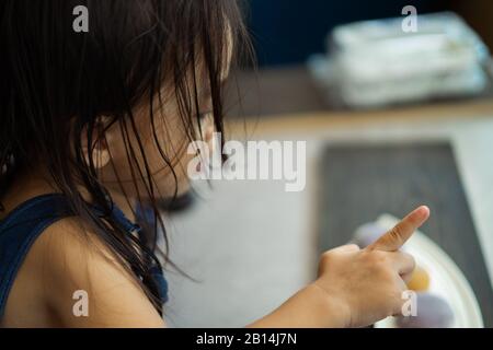 Asian toddler girl pointing somewhere. Rear view. Stock Photo