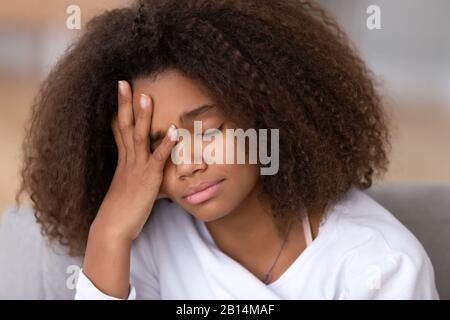 Sad or bored african american teen girl feeling headache sleepiness Stock Photo