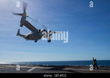 A U.S. Navy sailor with the amphibious assault ship USS Wasp (LHD 1) guides an MV-22B Osprey tiltrotor aircraft with Marine Medium Tiltrotor Squadron 265 (Reinforced), 31st Marine Expeditionary Unit, to land during flight operations aboard the Wasp in the Coral Sea, July 15, 2019. Wasp, flagship of the Wasp Amphibious Ready Group, with embarked 31st MEU, is currently participating in Talisman Sabre 2019 off the coast of Northern Australia. A bilateral, biennial event, Talisman Sabre is designed to improve U.S. and Australian combat training, readiness and interoperability through realistic, re