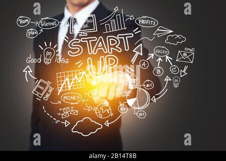 business, startup, presentation, strategy and people concept - business man in suit with startup diagram sketch popup from hand with light effect Stock Photo