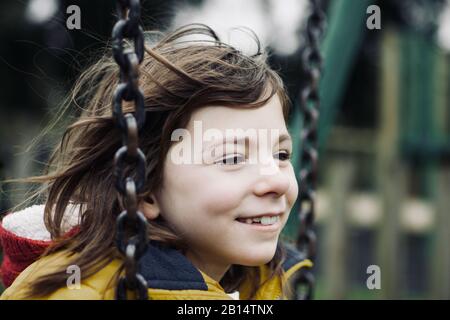 Girl smiling on a swing Stock Photo