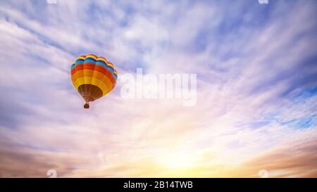 Colorful hot air balloon flying over the sky as background at sunrise Stock Photo