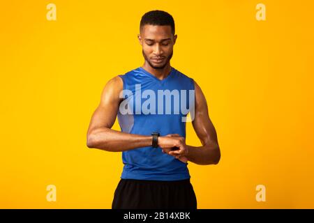 Confident afro guy looking at his smart watch Stock Photo