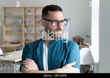 Stressed frowning young businessman looking away. Stock Photo