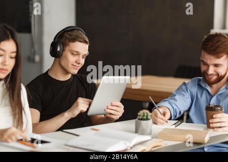 Student guy surfing net on tablet in library Stock Photo