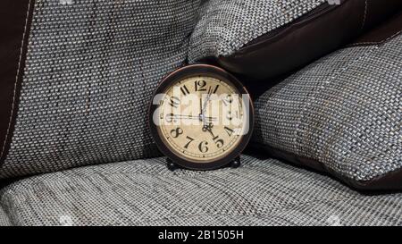 Summer Daylight Saving Time (DST) concept. Retro styled Clock with pillows. Stock Photo