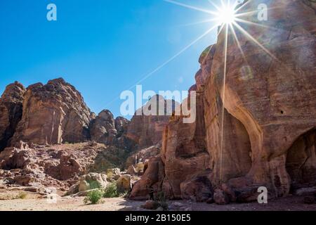 Cliffs and tombs that could be seen when walking the scenery Street of Facades, created hundreds of years. Petra complex tourist attraction, Hashemite Kingdom of Jordan. Sunlight diffraction effect
