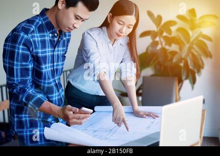Construction , designer and renovate concept. - Architects working with blueprints in the office. Confident team of young Asian engineers working Stock Photo