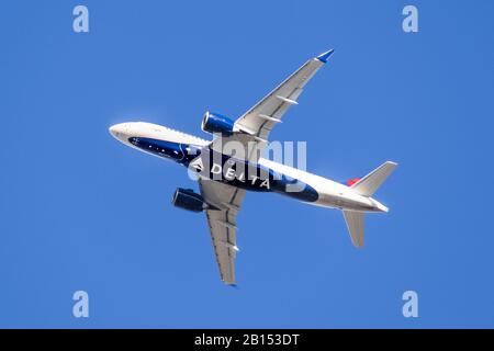 Feb 18, 2020 San Jose / CA / USA - Delta Airlines aircraft in flight; the Delta Logo visible on the airplanes' underbelly; blue sky background Stock Photo