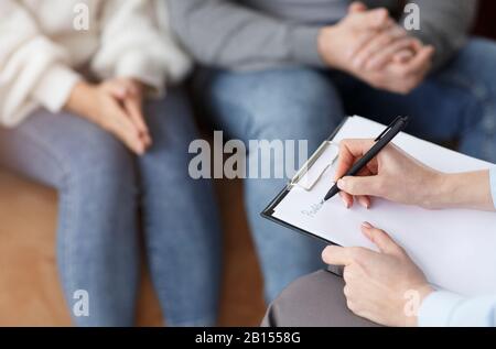Marriage Consultant Taking Notes Talking With Couple In Office, Cropped Stock Photo