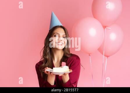 funny girl posing with piece of cake on birthday celebration party 2b155t7