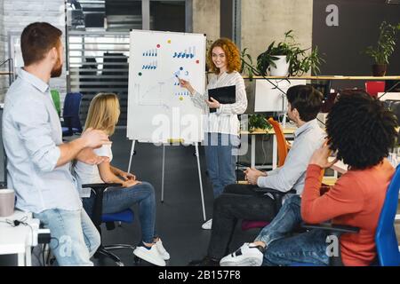 Young creative team analyzing information on graphs and charts Stock Photo