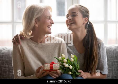 Happy middle aged elder woman listening to sincere congratulations. Stock Photo