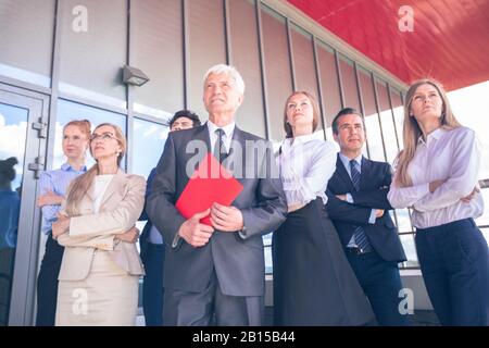 Successful Business People Standing Together and Looking at Their Bright Future Stock Photo