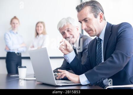 Business people working with laptop together in office Stock Photo