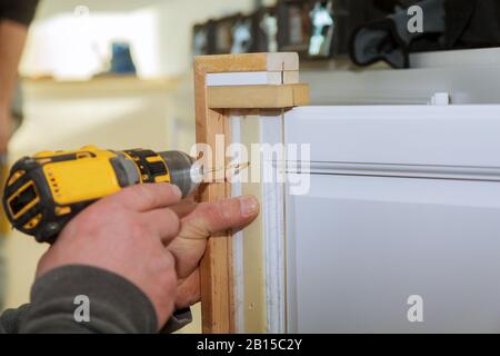 Cabinet door master drills the drilling a hole door Stock Photo