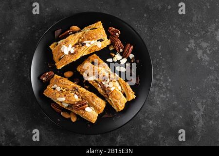 Homemade chocolate puff pastry braided strudel, pie with pecan nuts and almond, top view Stock Photo