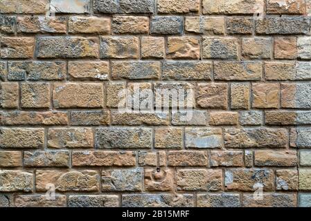 Brick or stone wall of an old house on the street in Florence, Italy. Background. Stock Photo
