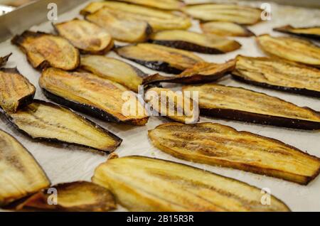 Eggplants baked on paper in a baking tray Stock Photo
