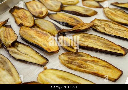 Eggplants baked on paper in a baking tray Stock Photo