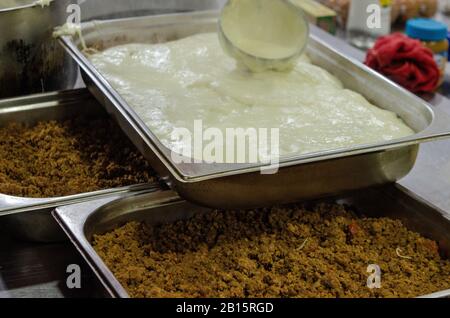 moussaka preparation bechamel in dish minced meat close up Stock Photo