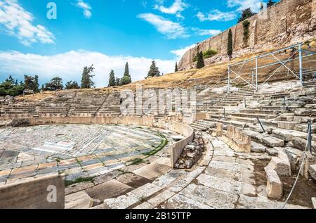 Ancient Greek ruins at the foot of Acropolis, Athens, Greece. Panorama of Theatre of Dionysus in summer. It is one of top landmarks in Athens. View to Stock Photo