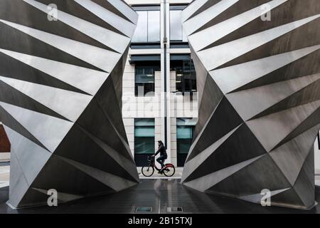 London urban photography: Cyclist passes Paternoster Vents, a stainless steel sculpture by Thomas Heatherwick. City of London, UK Stock Photo