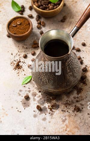 Morning coffee concept. Turkish coffee in Turk and coffee beans on a stone or slate countertop. Copy space. Stock Photo