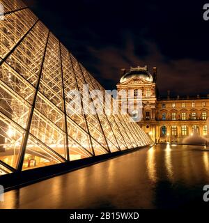 PARIS - SEPTEMBER 25: Louvre museum at night on september 25, 2013 in Paris. The Louvre is one of the largest museums in the world and one of the majo Stock Photo