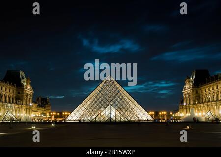 PARIS - SEPTEMBER 25, 2016: Louvre museum with the well-known glass pyramid at night. The Louvre is one of the largest museums in the world and one of
