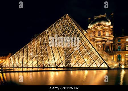 PARIS - SEPTEMBER 25: Louvre museum at night on september 25, 2013 in Paris. The Louvre is one of the largest museums in the world and one of the majo Stock Photo