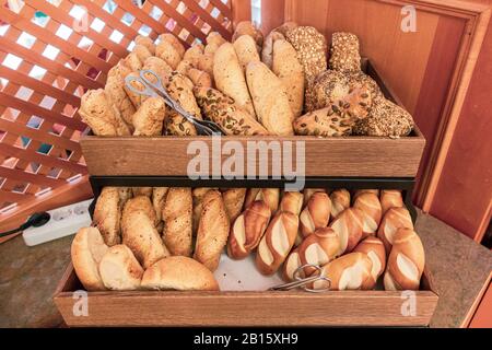 on a breakfast buffet there are two baskets filled with different kinds of bread rolls Stock Photo