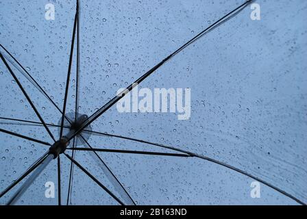 Raindrops Falling on Transparent Umbrella Stock Photo