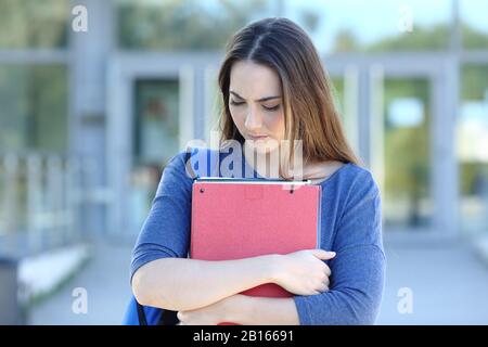 Sad student walking looking down complaining in an university campus Stock Photo