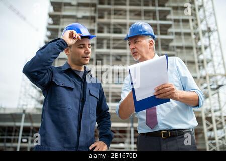 Engineer explaining a drawing to a worker Stock Photo