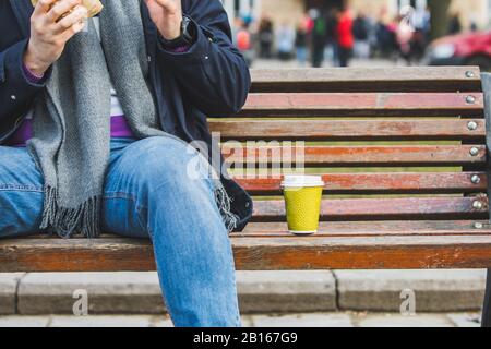 man hands close up holding burger with coffee cup Stock Photo
