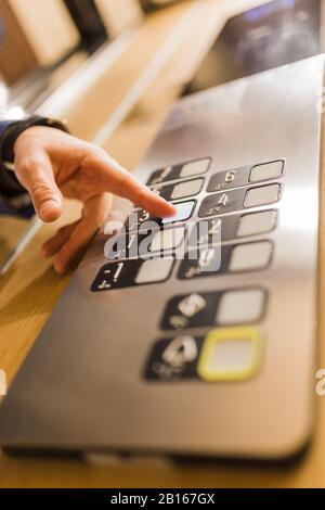 Man pressing modern elevator button with his forefinger. Stock Photo