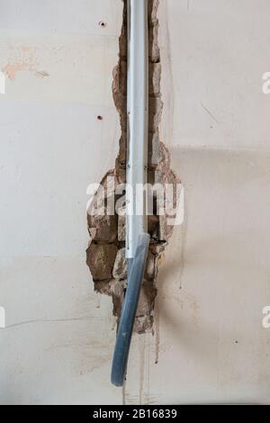 Exposed wiring in a channel in a brick wall as a room is being refurbished. Stock Photo