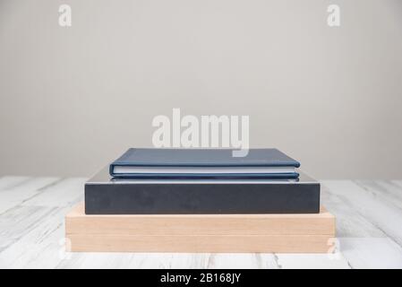 Stack of 3 albums books on isolated white blurred background with blank empty room space for text or copy. Stock Photo