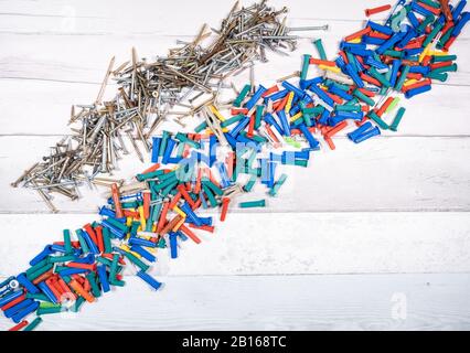 Set of screws and set of dowels of all colors on an old wooden background. top view. Stock Photo