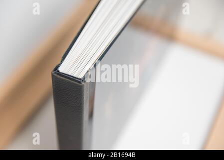 Close up view of photo album book binding - spine view of block. Black leather spine showing off sharp corners or edges. Stock Photo