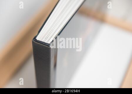 Close up view of photo album book binding - spine view of block. Black leather spine showing off sharp corners or edges. Stock Photo