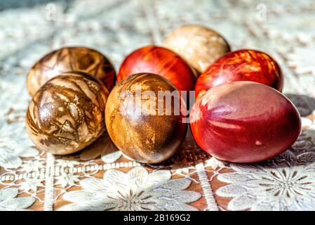 Multicolored easter eggs on a picnic table with a white tablecloth - image Stock Photo