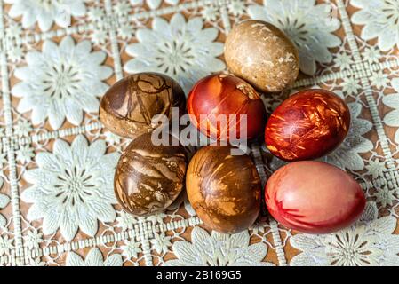 Multicolored easter eggs on a picnic table with a white tablecloth - image Stock Photo
