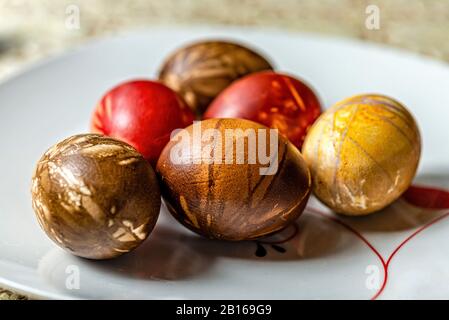 Multicolored easter eggs on a picnic table with a white tablecloth - image Stock Photo